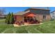 Outdoor patio featuring an orange umbrella, furniture, and landscaping at 2328 Discovery Dr, Anderson, IN 46017