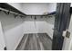 Walk-in closet with built-in shelving, hanging rods, and wood-look floors at 249 E Minnesota St, Indianapolis, IN 46225