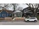 Charming home featuring green siding, white trim, a welcoming front porch and a modern horizontal wood fence at 249 E Minnesota St, Indianapolis, IN 46225