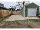 View of garage with white door and green exterior with a concrete pad outside, offering parking and storage solutions at 249 E Minnesota St, Indianapolis, IN 46225