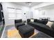 Bright living room features dark grey sectional and view into dining area and kitchen at 249 E Minnesota St, Indianapolis, IN 46225