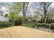Large wooden deck overlooking a backyard with mature trees and a patio area, great for entertaining at 2816 Canterbury Ln, Indianapolis, IN 46220