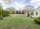 Picturesque backyard with tall evergreens, a wooden fence, and a cozy fire pit at 2816 Canterbury Ln, Indianapolis, IN 46220