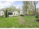 Expansive backyard featuring a screened porch, mature trees, and a fire pit at 2816 Canterbury Ln, Indianapolis, IN 46220
