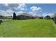 Spacious backyard with lush green grass, mature trees, and storage shed add to the property's value at 300 Kathryn Ct, Clayton, IN 46118