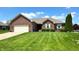Charming brick home featuring a manicured lawn, attached garage, and neat landscaping, perfect for suburban living at 300 Kathryn Ct, Clayton, IN 46118