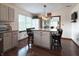 Stylish kitchen island featuring granite countertops, a pendant light, and barstool seating, seamlessly connects to the dining area at 300 Kathryn Ct, Clayton, IN 46118