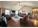 Bright living room featuring hardwood floors, vaulted ceiling, ceiling fan, and comfortable leather furniture at 300 Kathryn Ct, Clayton, IN 46118