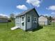 Backyard storage shed with a ramp and adjacent grass provides extra storage space at 300 Kathryn Ct, Clayton, IN 46118