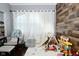 Bright playroom features hardwood floors, wood paneled accent wall, play area, and lots of toys at 3438 Olive St, Indianapolis, IN 46227