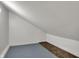The attic has sloped ceilings, white walls, and a gray floor plus a carpet for extra space at 3484 Birchwood Ave, Indianapolis, IN 46205