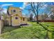 The backyard offers ample green space, a patio area, mature tree, and yellow siding at 3484 Birchwood Ave, Indianapolis, IN 46205