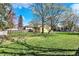 Large backyard providing ample space with established trees, partially fenced for privacy and security at 3484 Birchwood Ave, Indianapolis, IN 46205