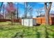 A fenced backyard with green grass, a storage shed, and a small pink flowering tree at 3484 Birchwood Ave, Indianapolis, IN 46205