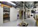 Unfinished basement with concrete walls, shelving, utility access, and a sturdy pump system at 3484 Birchwood Ave, Indianapolis, IN 46205