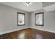Empty bedroom features hardwood floors, two windows and neutral paint at 3484 Birchwood Ave, Indianapolis, IN 46205