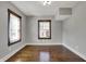 Empty bedroom features hardwood floors, two windows and neutral paint at 3484 Birchwood Ave, Indianapolis, IN 46205