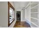 Spacious walk-in closet with custom shelving and wood floors, complemented by a window at 3484 Birchwood Ave, Indianapolis, IN 46205