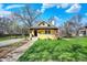 Inviting exterior of a yellow home with a beautifully landscaped front yard and blue skies at 3484 Birchwood Ave, Indianapolis, IN 46205