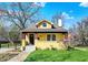 Charming yellow home with a dormer window, quaint front porch and well-maintained lawn at 3484 Birchwood Ave, Indianapolis, IN 46205