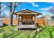 Cozy backyard gazebo with seating, set amidst a lush green lawn and mature trees at 3484 Birchwood Ave, Indianapolis, IN 46205