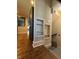 Hallway view featuring hardwood floors, built-in shelving, stainless steel refrigerator, and stairs at 3484 Birchwood Ave, Indianapolis, IN 46205