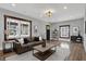 Staged living room featuring hardwood floors, neutral walls, and a comfortable brown leather sofa at 3484 Birchwood Ave, Indianapolis, IN 46205