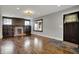 A spacious living room with hardwood floors, a brick fireplace, and large windows at 3484 Birchwood Ave, Indianapolis, IN 46205