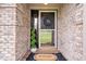 Inviting front entrance featuring a decorative wreath, a 'Welcome' mat, and a potted plant, adding charm to the brick facade at 4223 W State Road 234, McCordsville, IN 46055