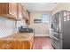 Functional laundry room with wooden countertop, cabinetry, and stainless steel refrigerator at 4223 W State Road 234, McCordsville, IN 46055