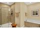 Bright bathroom featuring a shower with glass doors, a tub, wood stool, and neutral tones at 435 Virginia Ave # 402, Indianapolis, IN 46203