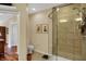 Bathroom with a tiled shower, toilet, and wooden floors leading into the adjacent room at 435 Virginia Ave # 402, Indianapolis, IN 46203