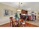 Dining room showcasing kitchen bar with seating, wood floors, and modern chandelier at 435 Virginia Ave # 402, Indianapolis, IN 46203