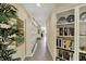 Long hallway with decorative plants, beige walls, built in shelving, and porcelain decorations at 435 Virginia Ave # 402, Indianapolis, IN 46203