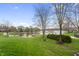 Expansive backyard with lush green lawn, mature trees, and lake view at 4561 Coles Dr, Columbus, IN 47201