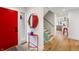 Modern entryway featuring a red door, glass railing staircase, and view to a modern kitchen at 4561 Coles Dr, Columbus, IN 47201