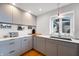 Modern kitchen featuring gray cabinets, stainless steel appliances, white countertops, and a bright window at 4561 Coles Dr, Columbus, IN 47201