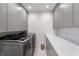 Sleek laundry room with gray cabinets, quartz countertop, and modern stainless steel washer and dryer at 4561 Coles Dr, Columbus, IN 47201
