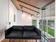 Modern living room featuring a black sofa, hardwood floors, and a stunning view of the lake at 4561 Coles Dr, Columbus, IN 47201