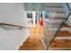Open staircase with wood steps, glass panels, and views into the living room below at 4561 Coles Dr, Columbus, IN 47201