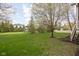 Lush backyard featuring a putting green, mature trees, and a white picket fence, creating a serene outdoor space at 4777 Madras Ct, Zionsville, IN 46077