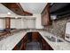 Elegant basement bar with sleek countertops, mosaic backsplash, built-in appliances and wood cabinetry at 4777 Madras Ct, Zionsville, IN 46077
