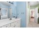 Bright bathroom with blue walls, a white vanity, and tiled flooring, offering a fresh and clean aesthetic at 4777 Madras Ct, Zionsville, IN 46077