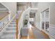 Spacious foyer featuring hardwood floors, staircase, and views into living spaces at 4777 Madras Ct, Zionsville, IN 46077
