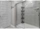 Modern shower with gray tiled walls, glass door, shower caddy, and a built-in shower head for a luxurious bath at 4831 E Oak Hill E Dr, Lebanon, IN 46052