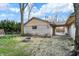 Backyard featuring a stone firepit, mature trees, and access to the covered carport area at 500 N Shellbark Rd, Muncie, IN 47304