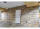 Spacious carport with stone walls and access to a fenced yard with landscaping at 500 N Shellbark Rd, Muncie, IN 47304