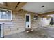 Covered carport area leading to fenced yard with a flower bed and a door at 500 N Shellbark Rd, Muncie, IN 47304