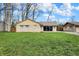 Well-maintained single-story home featuring a lush green lawn, mature trees, and charming curb appeal at 500 N Shellbark Rd, Muncie, IN 47304