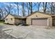Exterior view of a garage with stone siding and a well-maintained driveway with landscaping at 500 N Shellbark Rd, Muncie, IN 47304